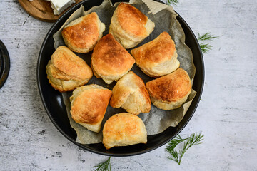 Fresh baked home made  Mini cheese puff pastries and cream  spread cheese.Cheese pie with phyllo pastry and herbs