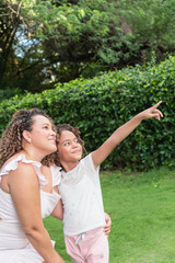 Fototapeta premium Latin Girl showing something to her mother in the park