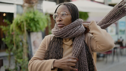 African woman putting scarf for cold weather at street