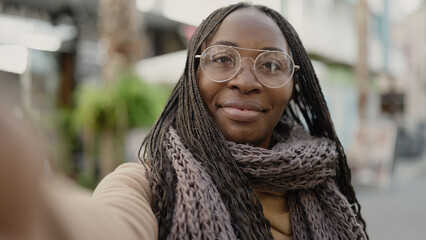 African woman taking selfie smiling at street