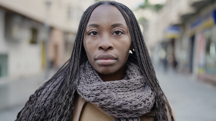 African woman standing with serious expression at street