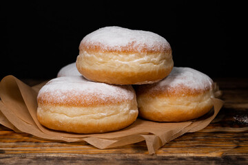 Polish pączki deep-fried doughnuts. Celebrating Fat Thursday (Tłusty czwartek) feast, traditional day in Poland. Pączek food, powdered sugar topped and filled with rose hip jam.