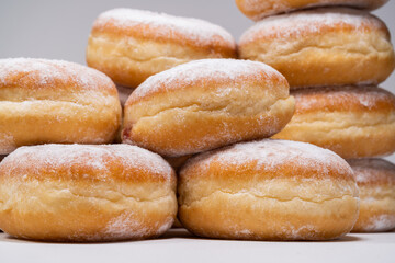 Polish pączki deep-fried doughnuts. Celebrating Fat Thursday (Tłusty czwartek) feast, traditional day in Poland. Pączek food, powdered sugar topped and filled with rose hip jam.