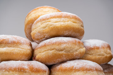 Polish pączki deep-fried doughnuts. Celebrating Fat Thursday (Tłusty czwartek) feast, traditional day in Poland. Pączek food, powdered sugar topped and filled with rose hip jam.