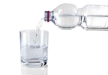 Clear and cool water poured in glass from 500ml pet plastic bottle, isolated on white with copy space
