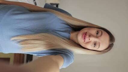 Vertical POV portrait of cheerful young woman talking via video chat using mobile phone looking at camera, on white isolated background in studio. Point of view of happy lady talking to camera. - Powered by Adobe