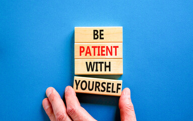 Patient with yourself symbol. Concept words Be patient with yourself on wooden blocks. Beautiful blue table blue background. Businessman hand. Business patient with yourself concept. Copy space.