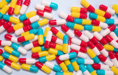 Creative layout of colorful pills and capsules on blue background. Minimal medical concept. Pharmaceutical, Medicine. Flat lay, top view.