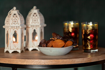Ramadan Kareem and iftar muslim food, holiday concept. Trays with nuts and dried fruits and latterns with candles. Celebration idea