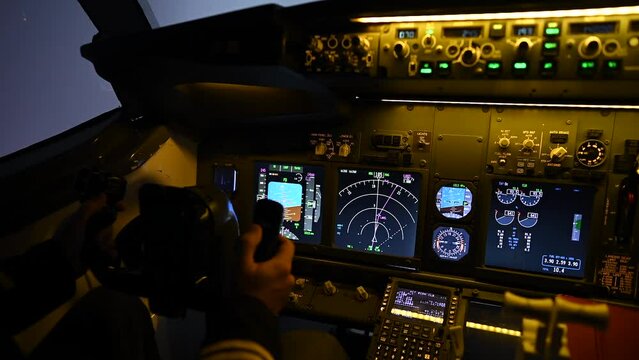 A man is studying to be a pilot in a flight simulator. Close-up of male hands navigating an aircraft.