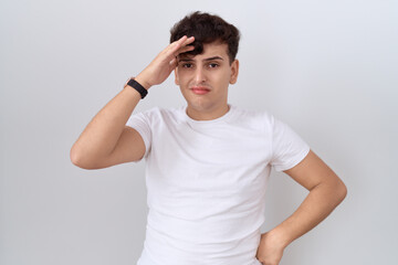 Young non binary man wearing casual white t shirt worried and stressed about a problem with hand on forehead, nervous and anxious for crisis