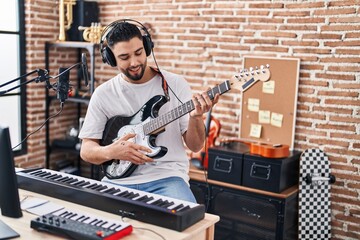 Young arab man artist singing song playing electrical guitar at music studio