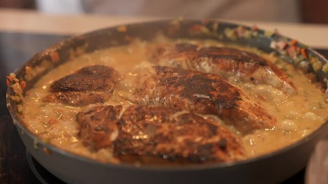 Slow motion close up of pan with fillets red snapper fish is stew in coconut milk. Popular Latin American dish Chillo al Coco 