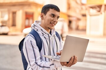 Fototapeta premium Young man student using laptop standing at street