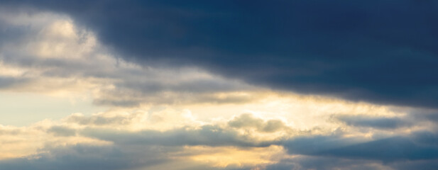 Naklejka na ściany i meble Dramatic sky with dark small clouds at sunset, panorama
