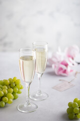Two glasses of wine white and red standing on a table with candle in the sun light
