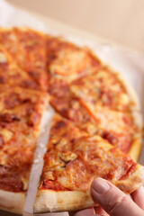 Fresh tasty sliced pizza closeup. Vertical Orientation