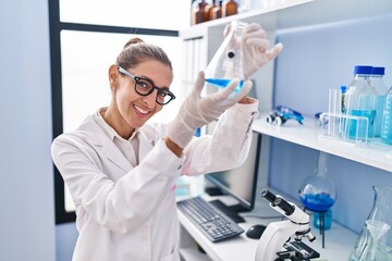 Young woman scientist measuring liquid at laboratory