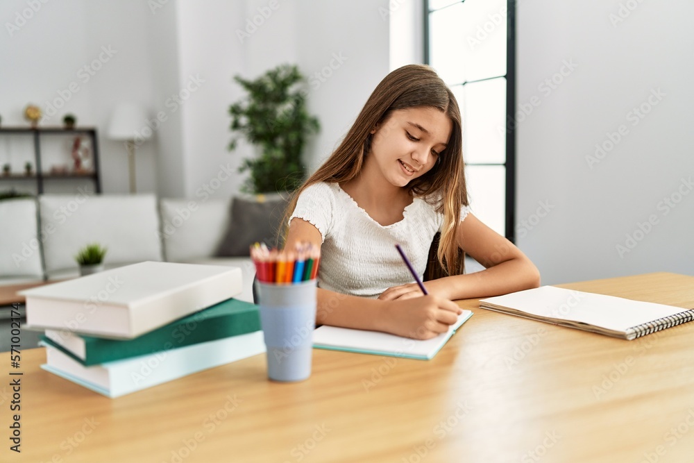 Canvas Prints Adorable girl doing homework sitting on table at home