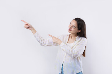 Happy young caucasian female in a shirt pointing fingers away