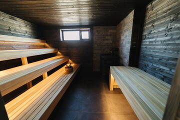 Modern interior of wooden spa cabin. View of empty Finnish sauna room with dry steam. New and fresh