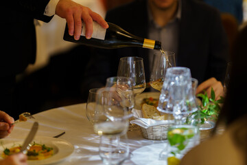 The sommelier serves wine