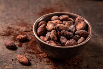 Tasy cocoa powder, beans and dark chocolate in a wooden background