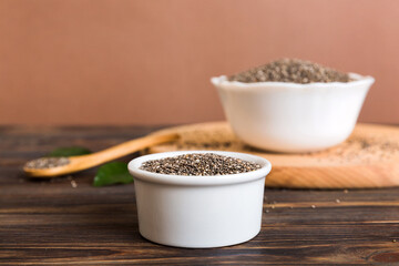 Chia seeds in bowl and spoon on colored background. Healthy Salvia hispanica in small bowl. Healthy superfood
