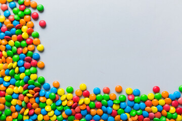 Mixed collection of colorful candy, on colored background. Flat lay, top view. frame of colorful chocolate coated candy