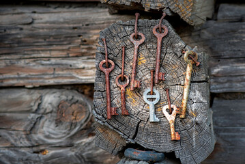 Many keys hanging on a wall of an old log house in countryside