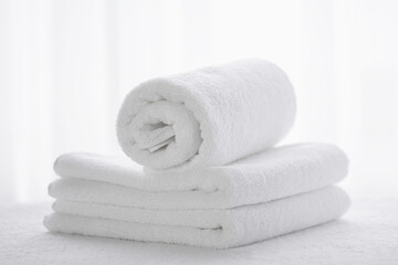 Obraz na płótnie Canvas White terry towels against a light window
