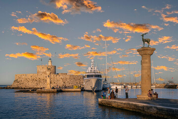 Afternoon view with the Mandraki Marina Port, symbolic deer statues where the Colossus of Rhodes stood. Rhodes, Greece - obrazy, fototapety, plakaty