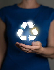 Woman holding abstract recycle sign. Global ecological responsibility and clean future concept.