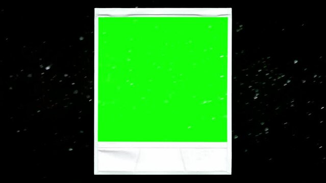 The retro vintage frame of an old white instant photo, zoom in, surrounded by dancing dust particles. Green interior.
