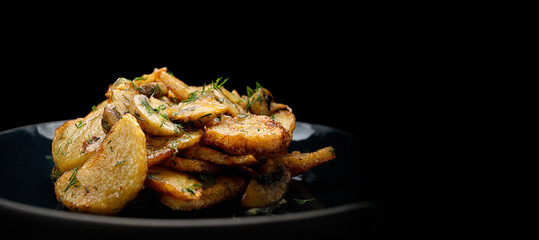 fried potatoes with mushrooms and dill in a dark plate