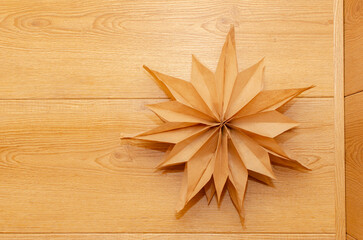 Decorative star made from paper on wooden backgrpund