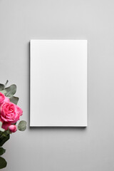 Blank picture canvas mockup hanging on grey wall and bouquet of pink roses with eucalyptus leaves. Blank photo frame, interior decor