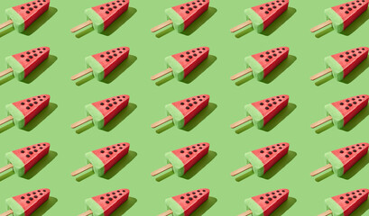 Watermelon popsicle ice cream on green pastel background. Fruity pattern. Flat lay.