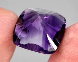 Natural gemstone purple amethyst on gray background
