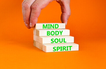 Mind body soul spirit symbol. Concept words Mind Body Soul Spirit on wooden blocks. Beautiful orange table orange background. Businessman hand. Lifestyle mind body soul spirit concept. Copy space.