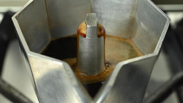 Boiling espresso that comes out of an old moka, close-up.