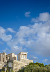 View of part of the Acropolis against a blue sky with white clouds, with copyspace