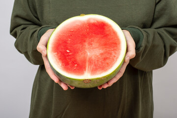 Woman showing fresh ripe sliced watermelon holding by hand