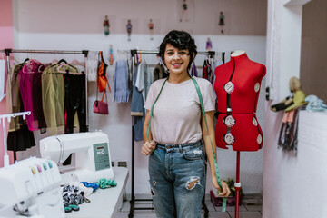 young hispanic woman fashion designer stylish working with mannequins standing and colorful fabrics...