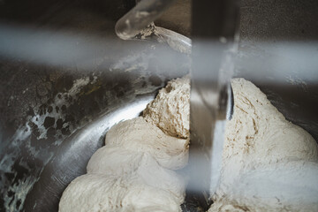 Bread dough being mixed in a professional industrial mixing machine in a bakery