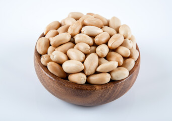 : Bowl full of roasted peeled peanuts on white background 