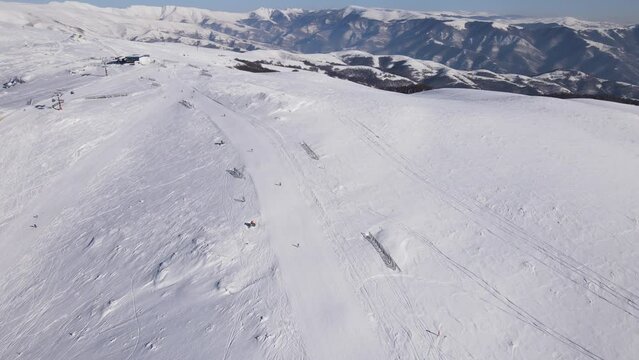 Skier on the ski slope piste downhill skiing in winter day on snow in Old Mountain Stara planina Babin Zub resort tourist destination drone aerial view
