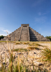 Fototapeta na wymiar Photo of the pyramid in Chichen Itza taken through the plants.