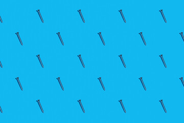 Rows of silver metal screws against a blue background