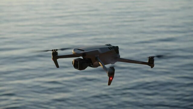 Montenegro, january 2023: drone dji mavic 3 hover in point, sea on background. filmmaker traveling with drone. propellers of drone rotate in slow motion